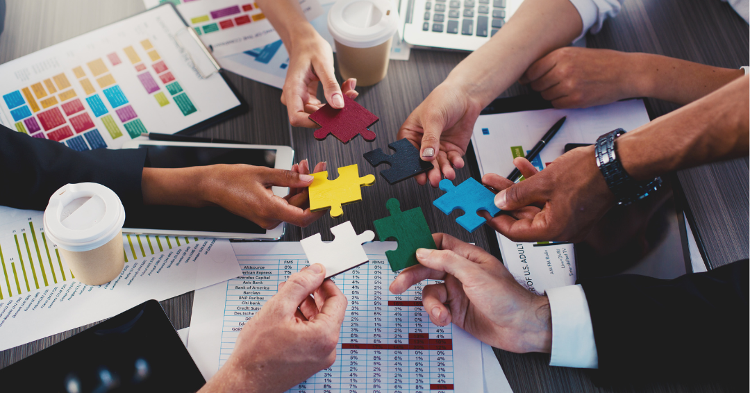 business people putting together giant puzzle pieces.