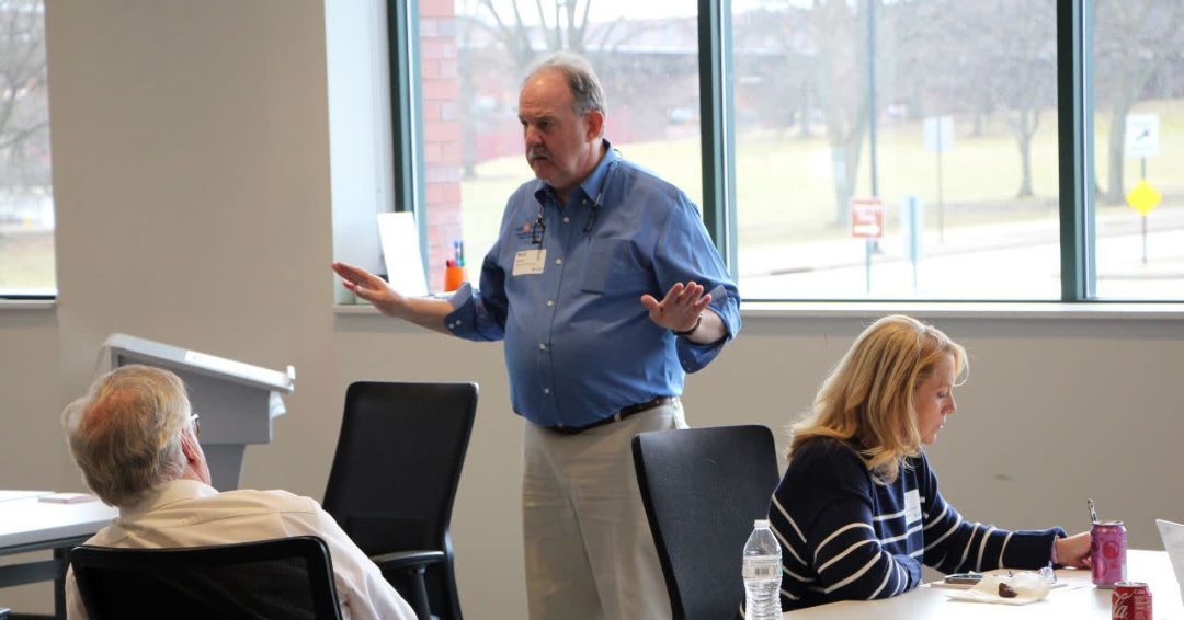Ned standing in front of a class speaking