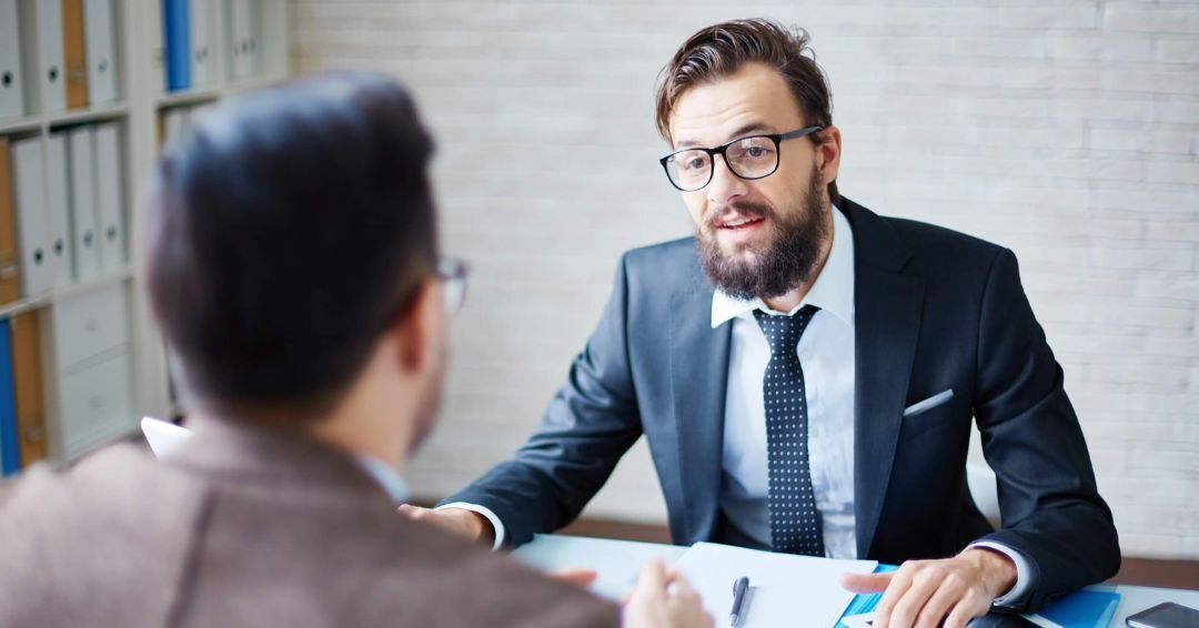 Two men sitting at a table talking