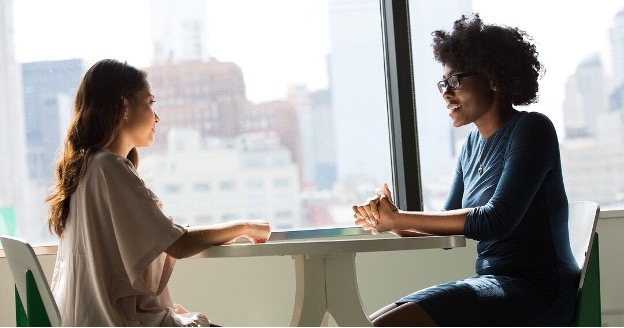 Two people sitting at a table conversing