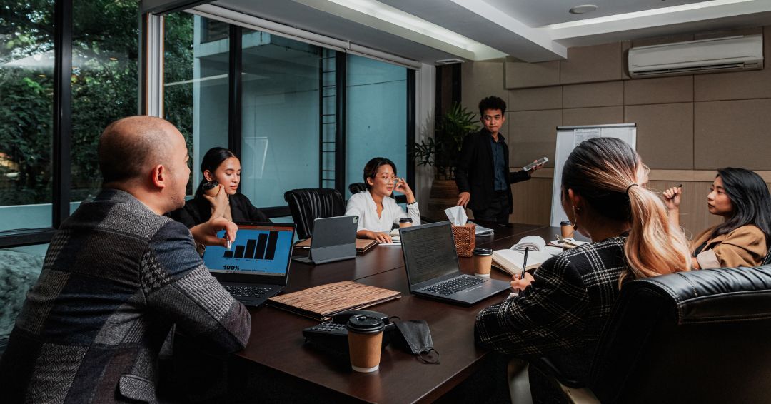 people sitting a desk having a meeting
