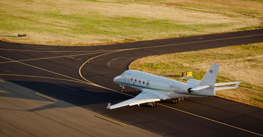 small jet landing on a runway